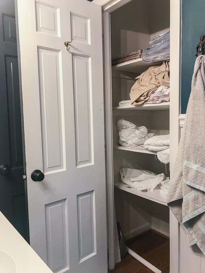 messy linen closet before