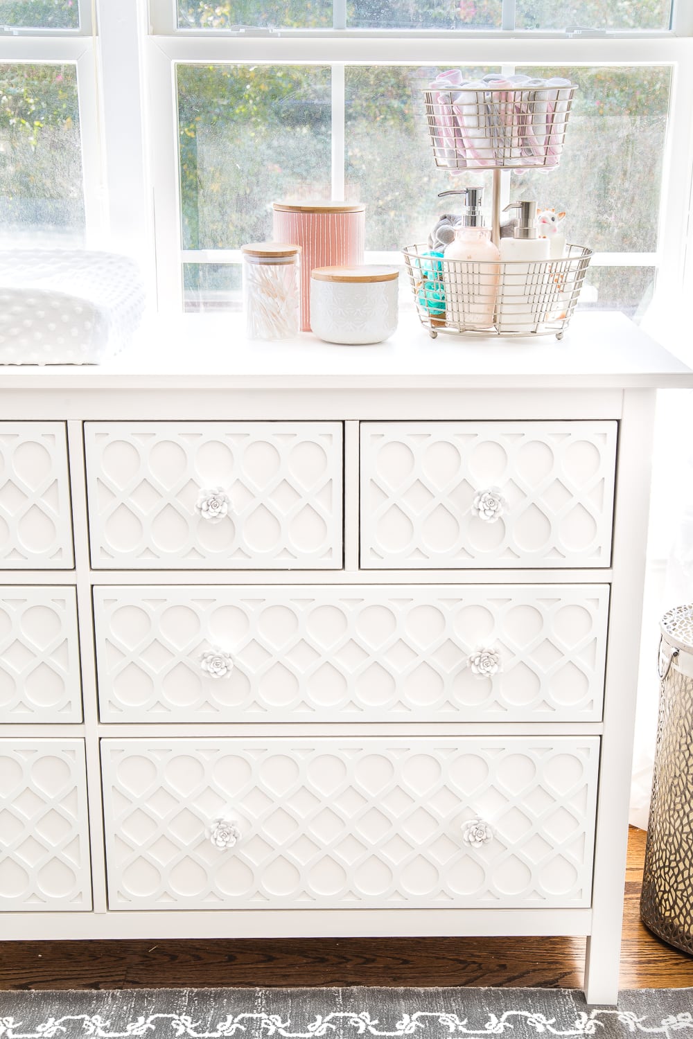 An all white nursery makeover room reveal with classic, vintage style furniture, Anthropologie-inspired patterns and textures, and floral accents.