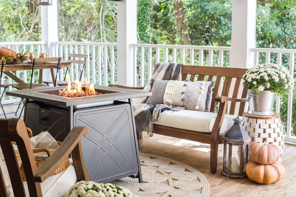 Cozy fall porch with gas fire pit, pumpkins, and mums