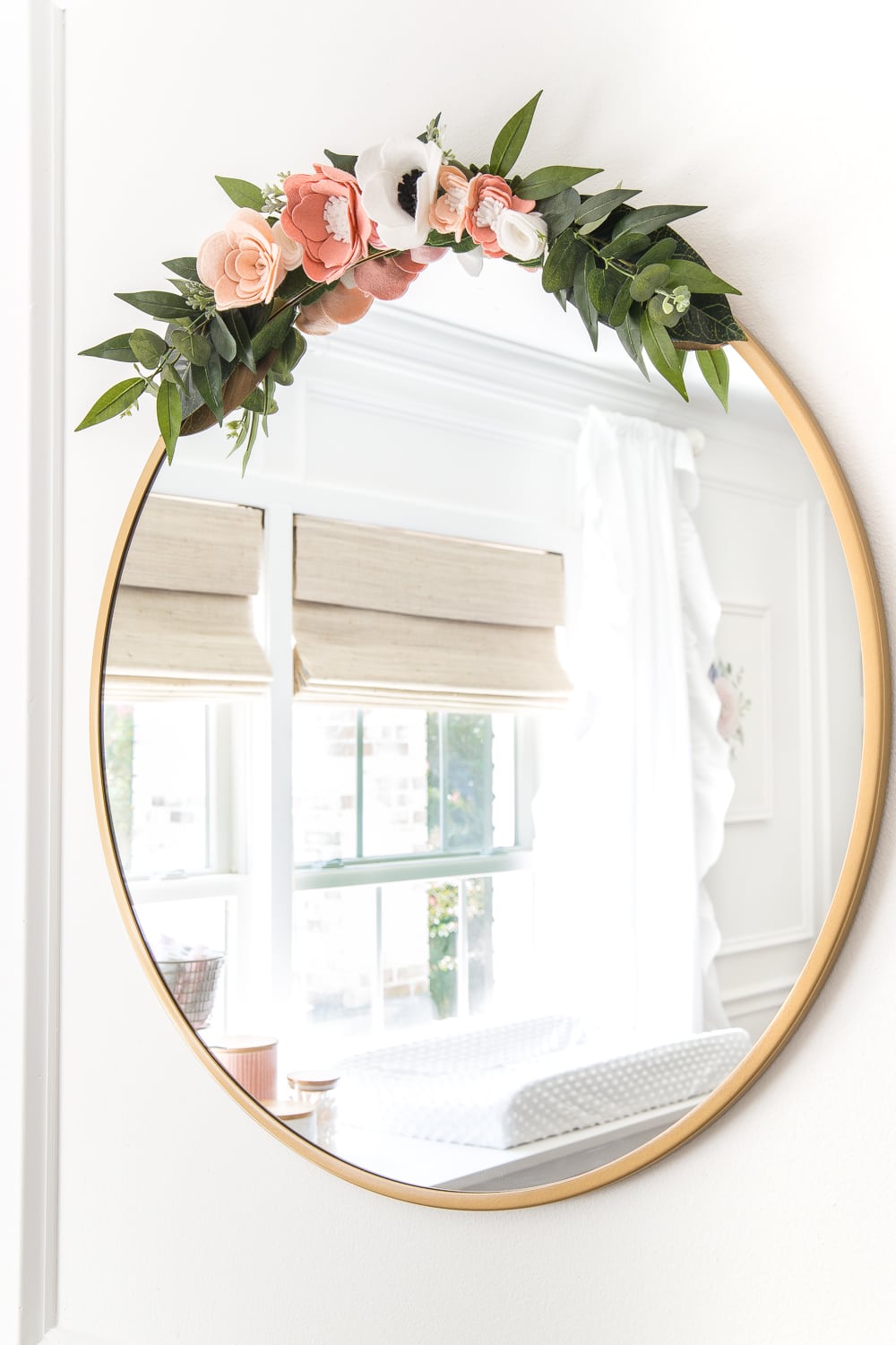 An all white nursery makeover room reveal with classic, vintage style furniture, Anthropologie-inspired patterns and textures, and floral accents.