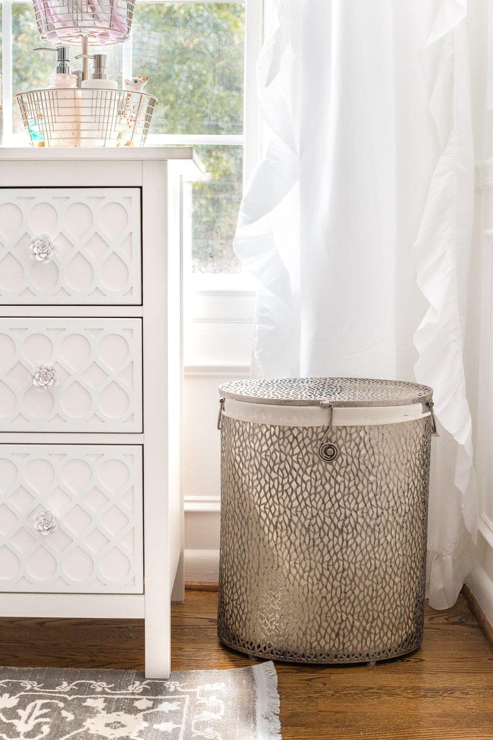 An all white nursery makeover room reveal with classic, vintage style furniture, Anthropologie-inspired patterns and textures, and floral accents.