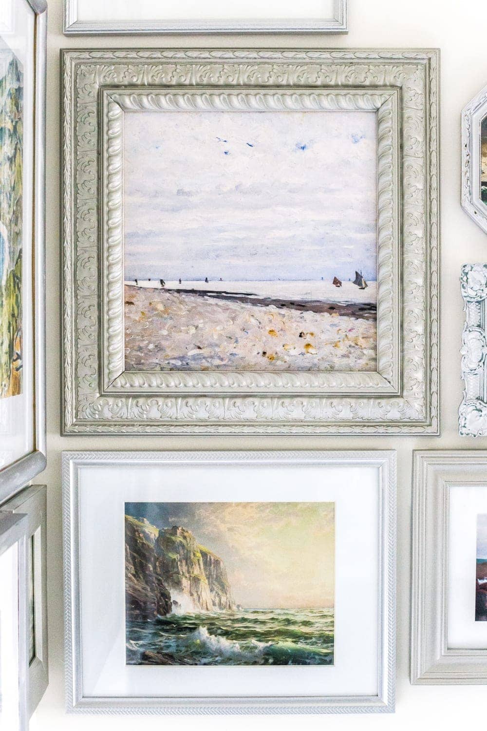 A free printable set of a coastal gallery wall featuring antique ocean paintings and how to frame them inexpensively with thrifted finds. #coastaldecor #gallerywall #bathroomart #bathroomwall #bathroomdecor #coastalart 