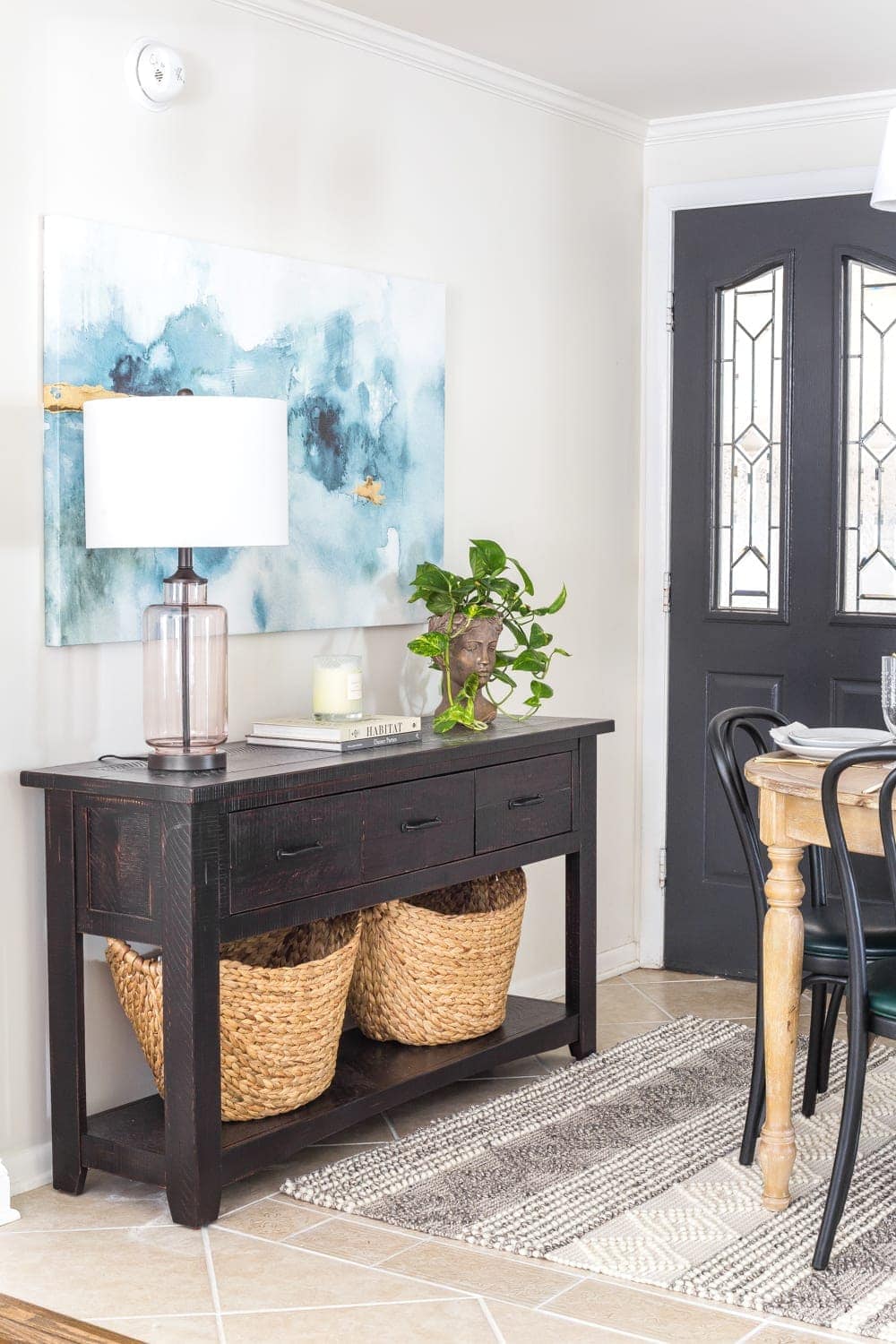 A console table beside an entry door in a breakfast nook to maximize on storage without the use of a mudroom. 