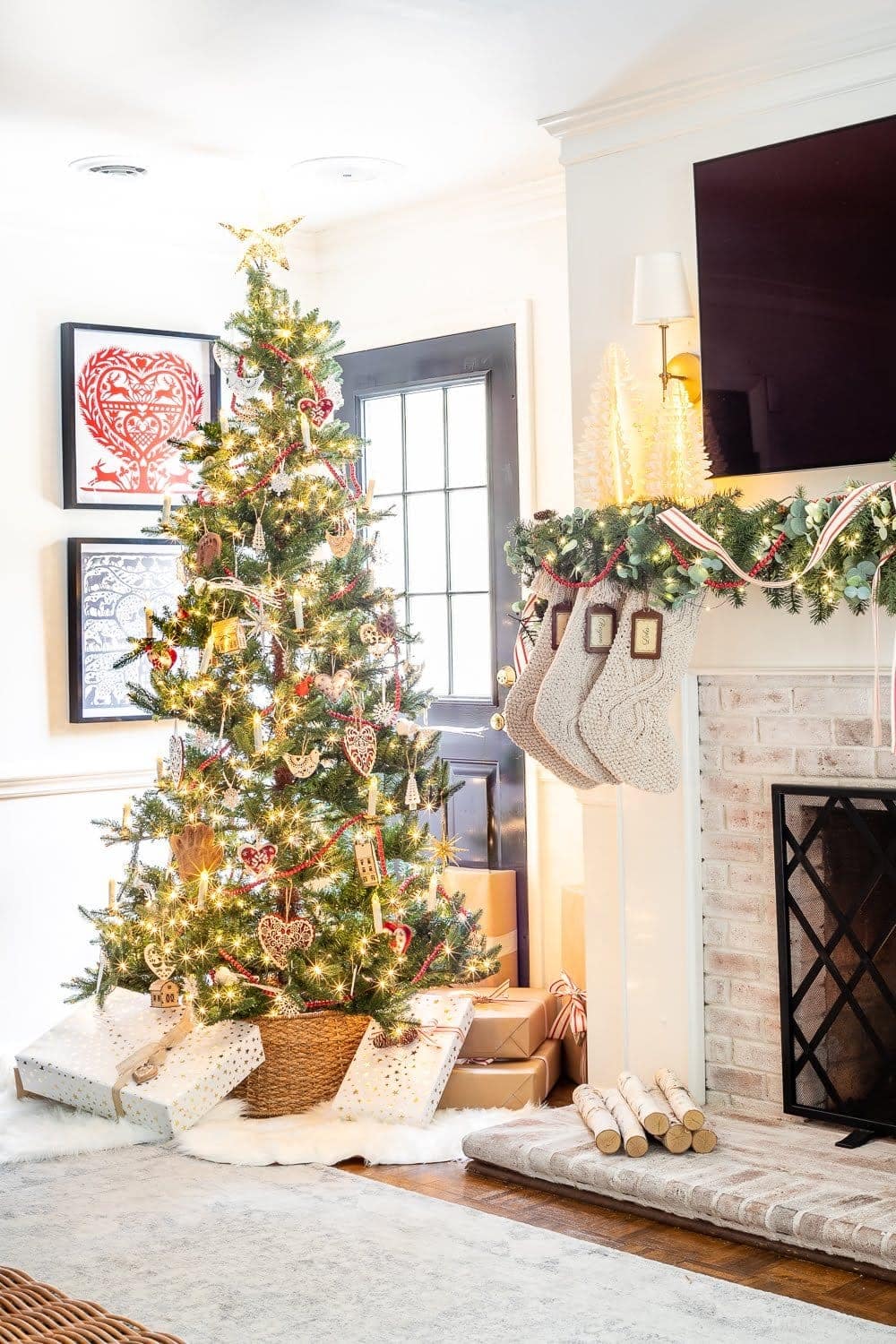 Swedish Christmas tree with Scandinavian inspired ornaments, abundant greenery, chunky knit stockings, nature touches, and pops of red.