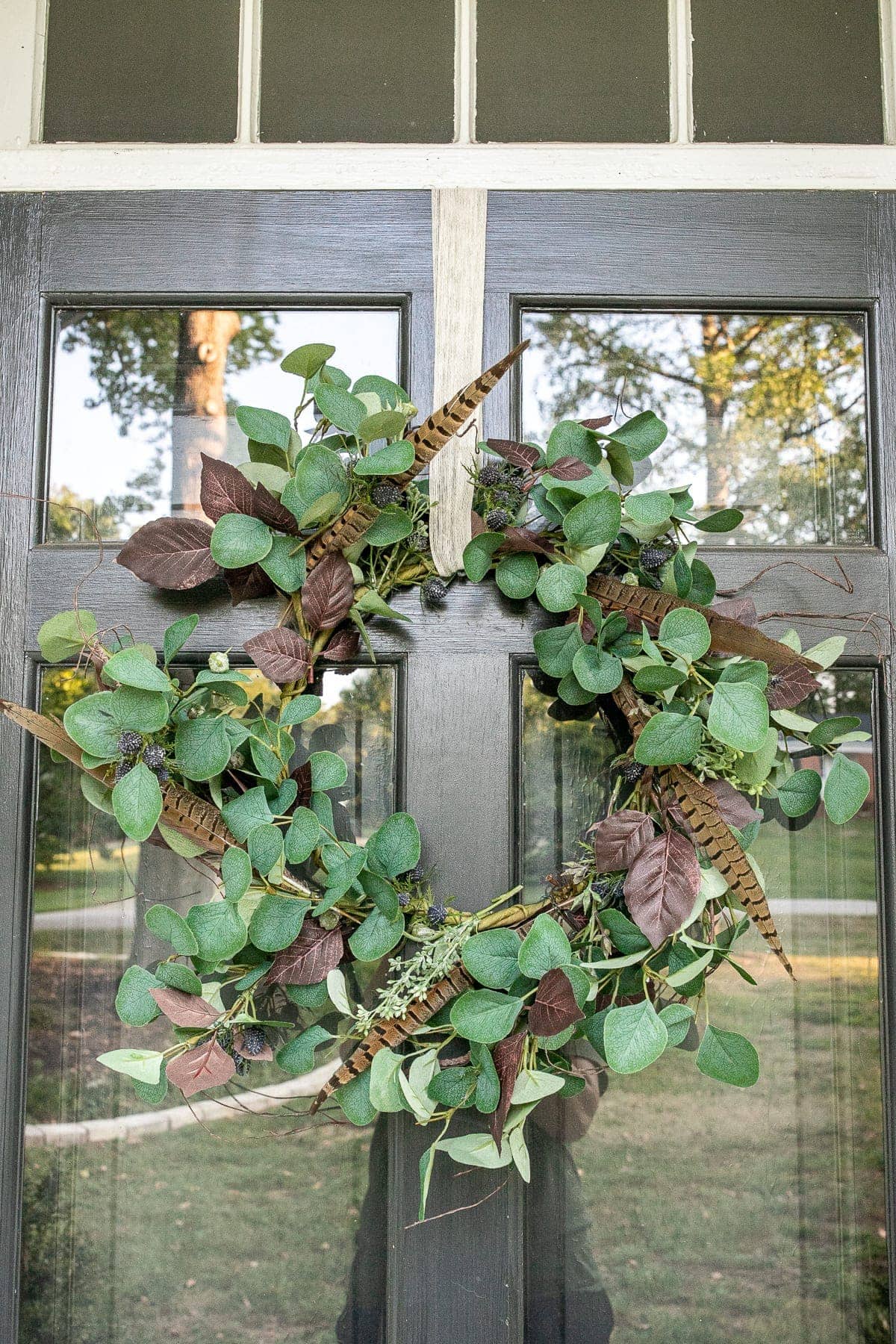 wreath decorated with feathers on a front door