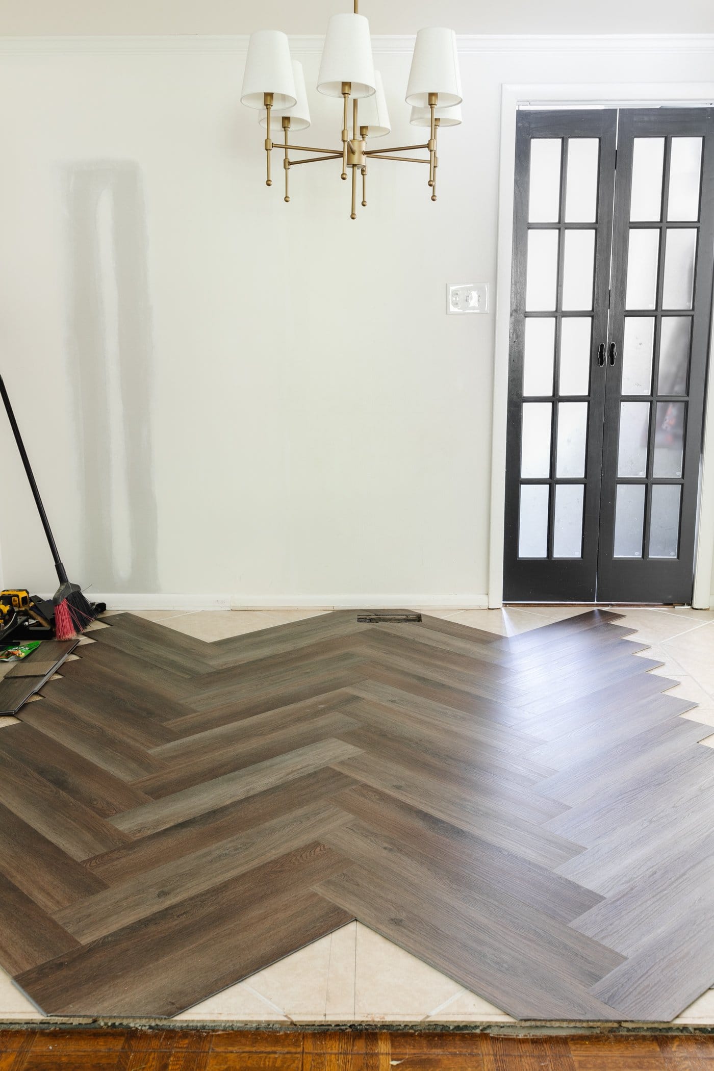 herringbone LVP floating floor installation over tile in a breakfast room