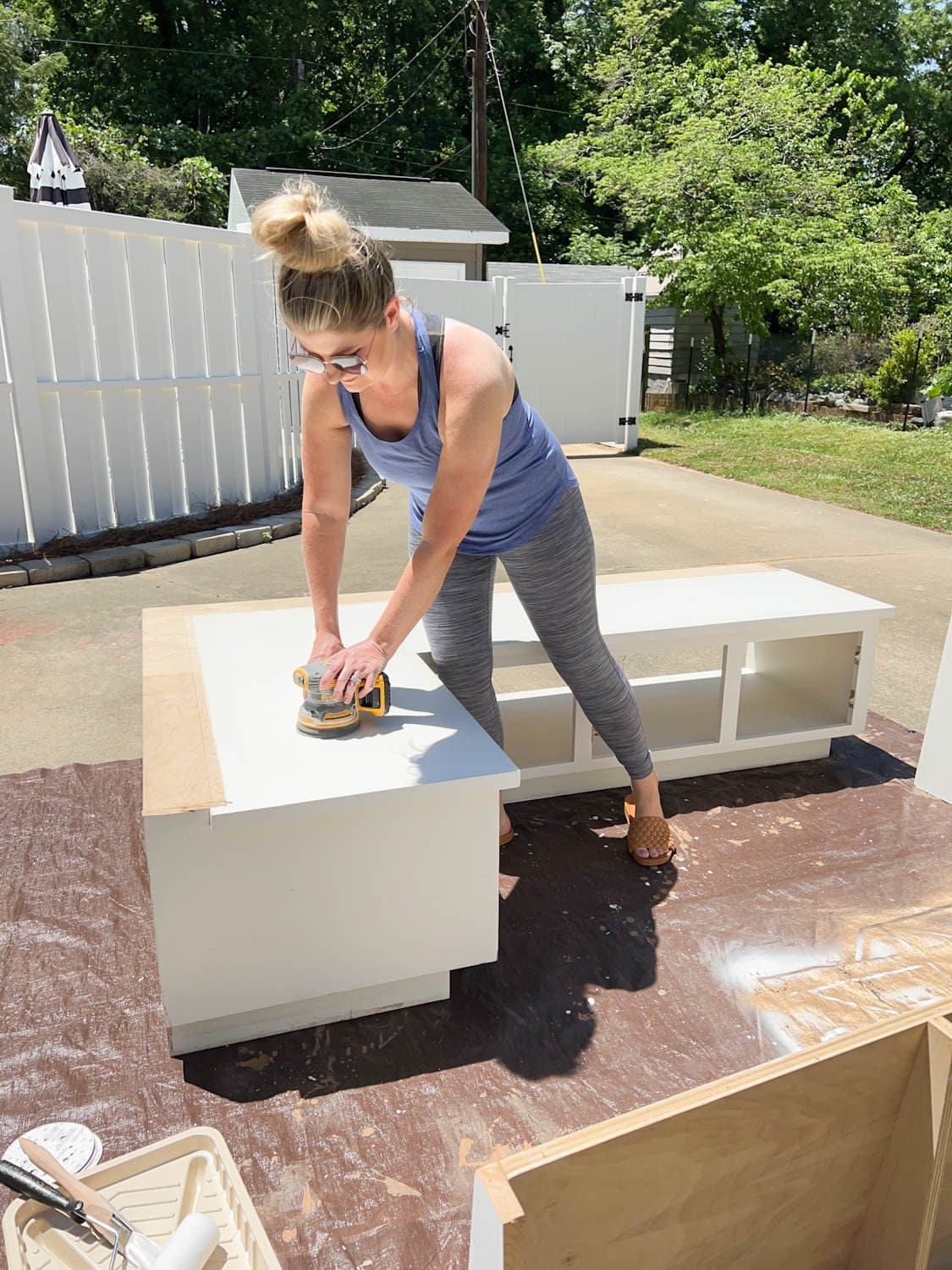 sanding a laminate corner banquette with an orbital sander