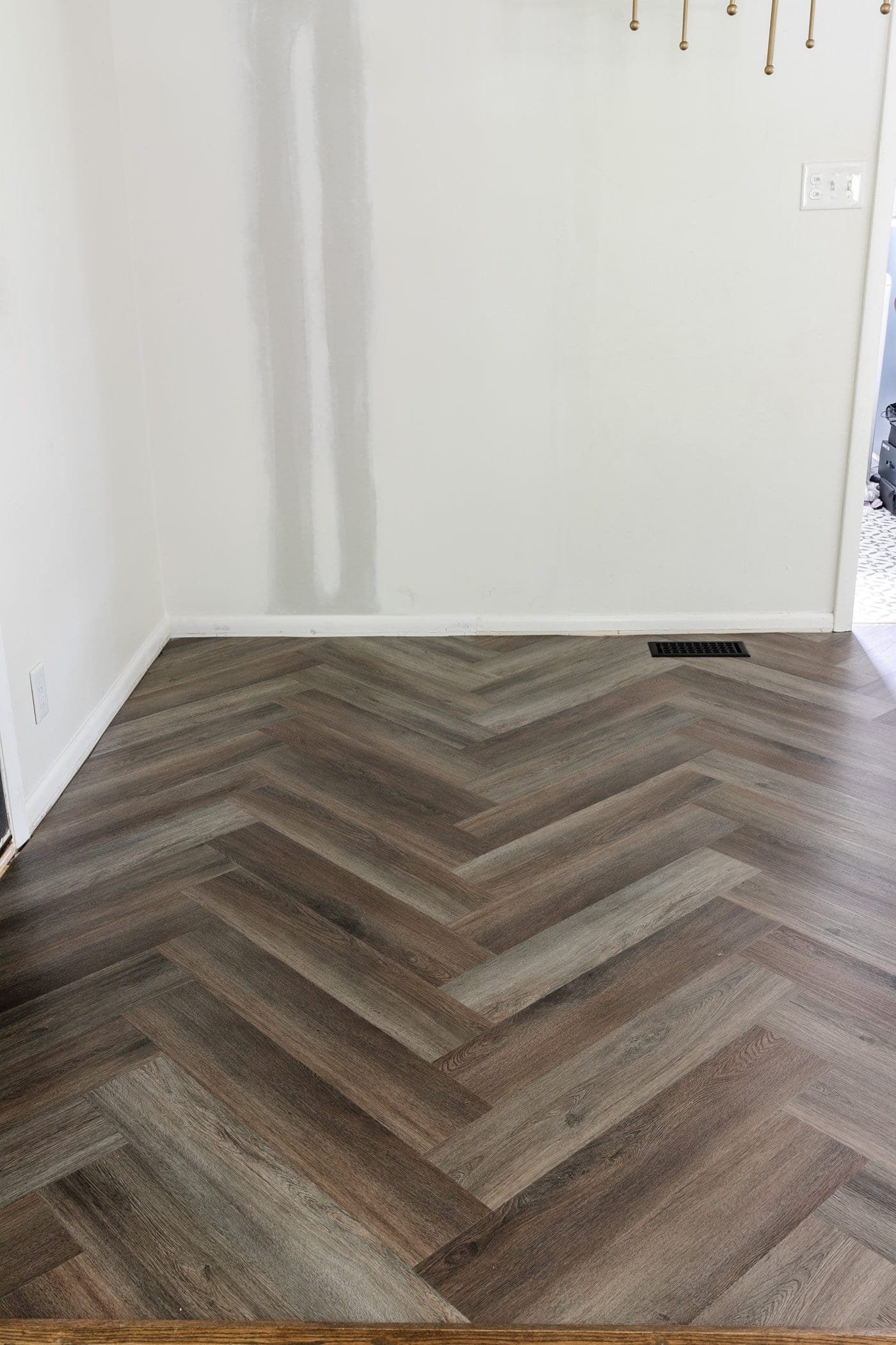 finished herringbone LVP floating floor over tile in a kitchen