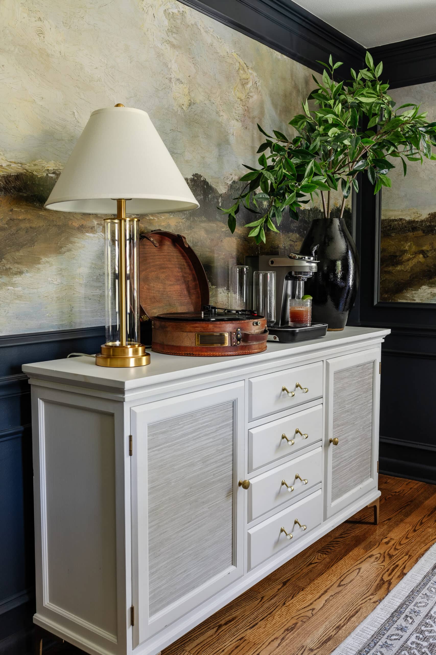 dining room buffet with Bartesian cocktail machine, record player, vase of branches, and lamp