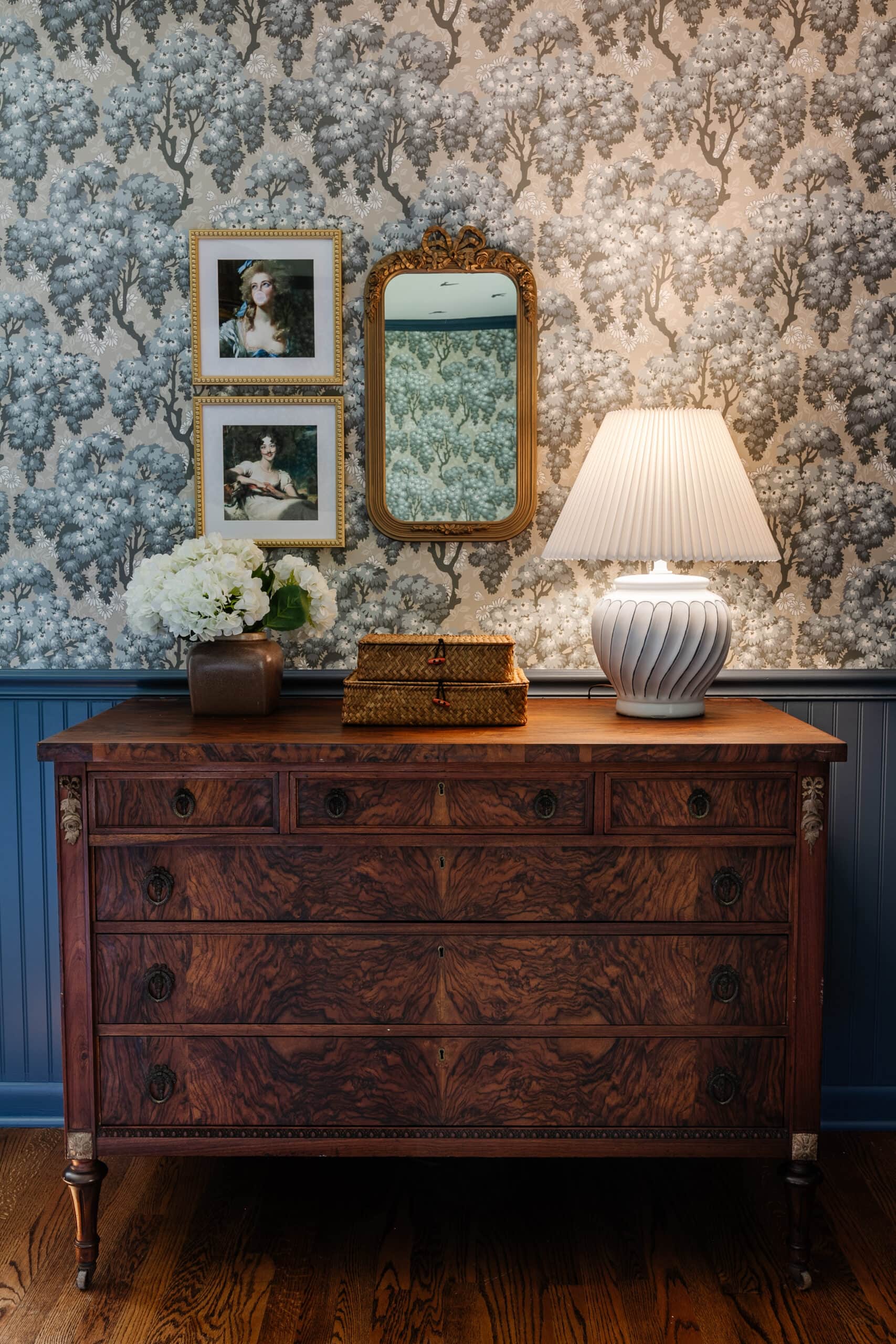 burl dresser dengan wallpaper swedia dan beadboard biru + potret antik yang diubah