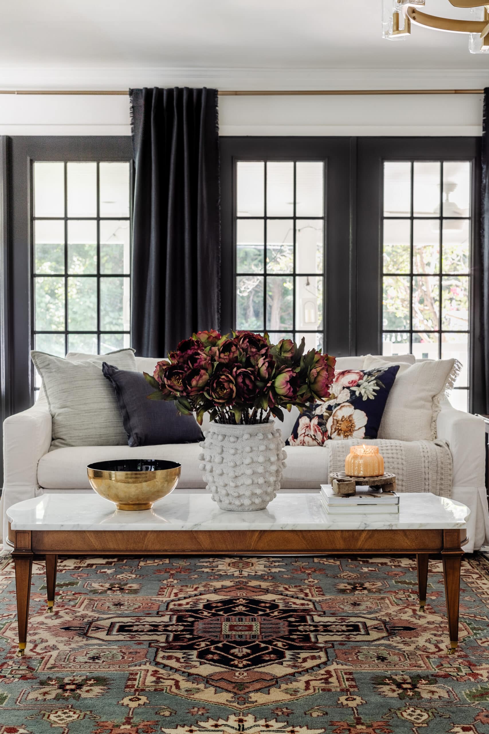 white living room sofa with marble coffee table decorated for fall with burgundy flowers