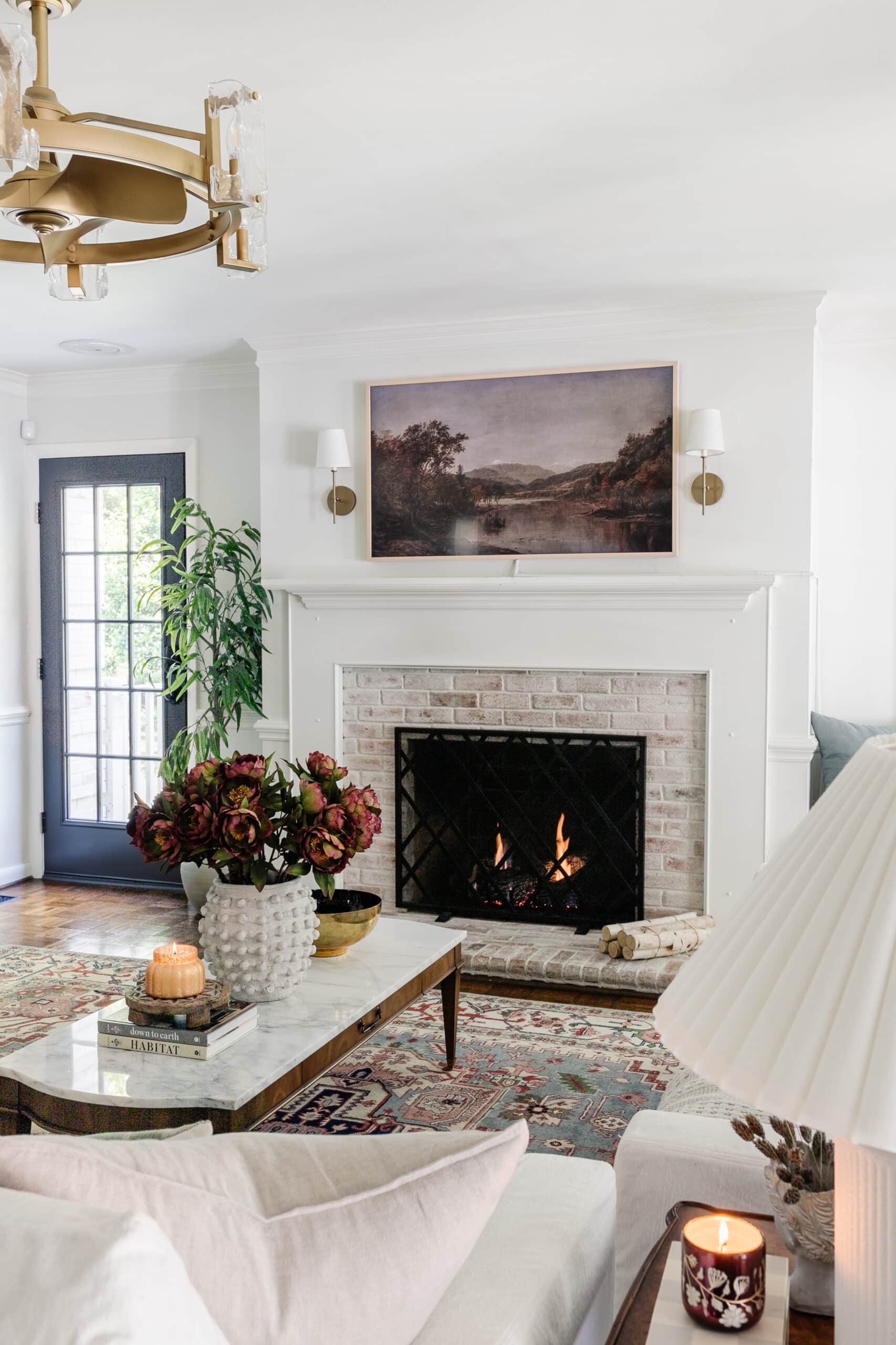 fall coffee table decor in a living room with limewashed brick fireplace