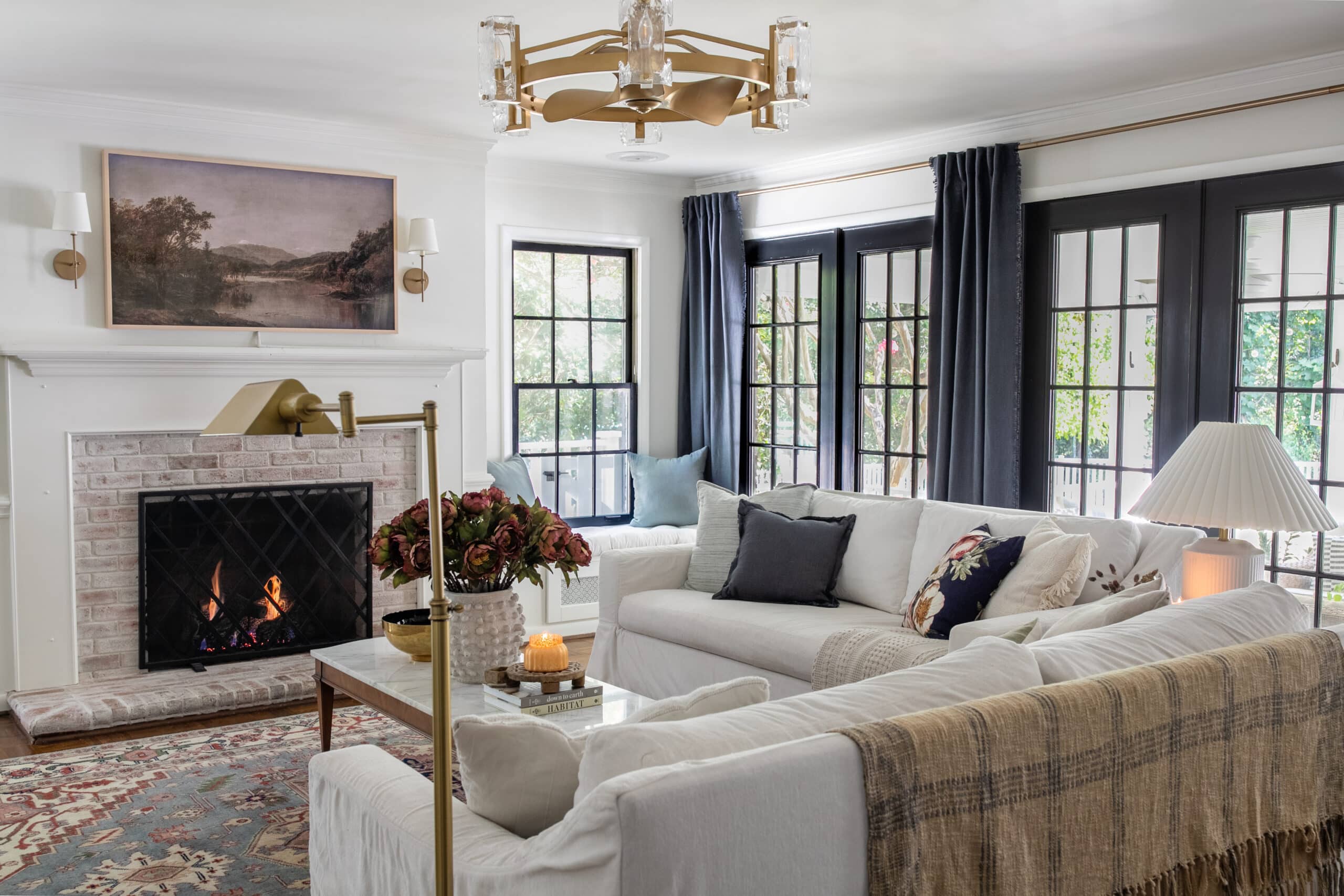 white living room with black windows blue curtains white sofas and fall decor