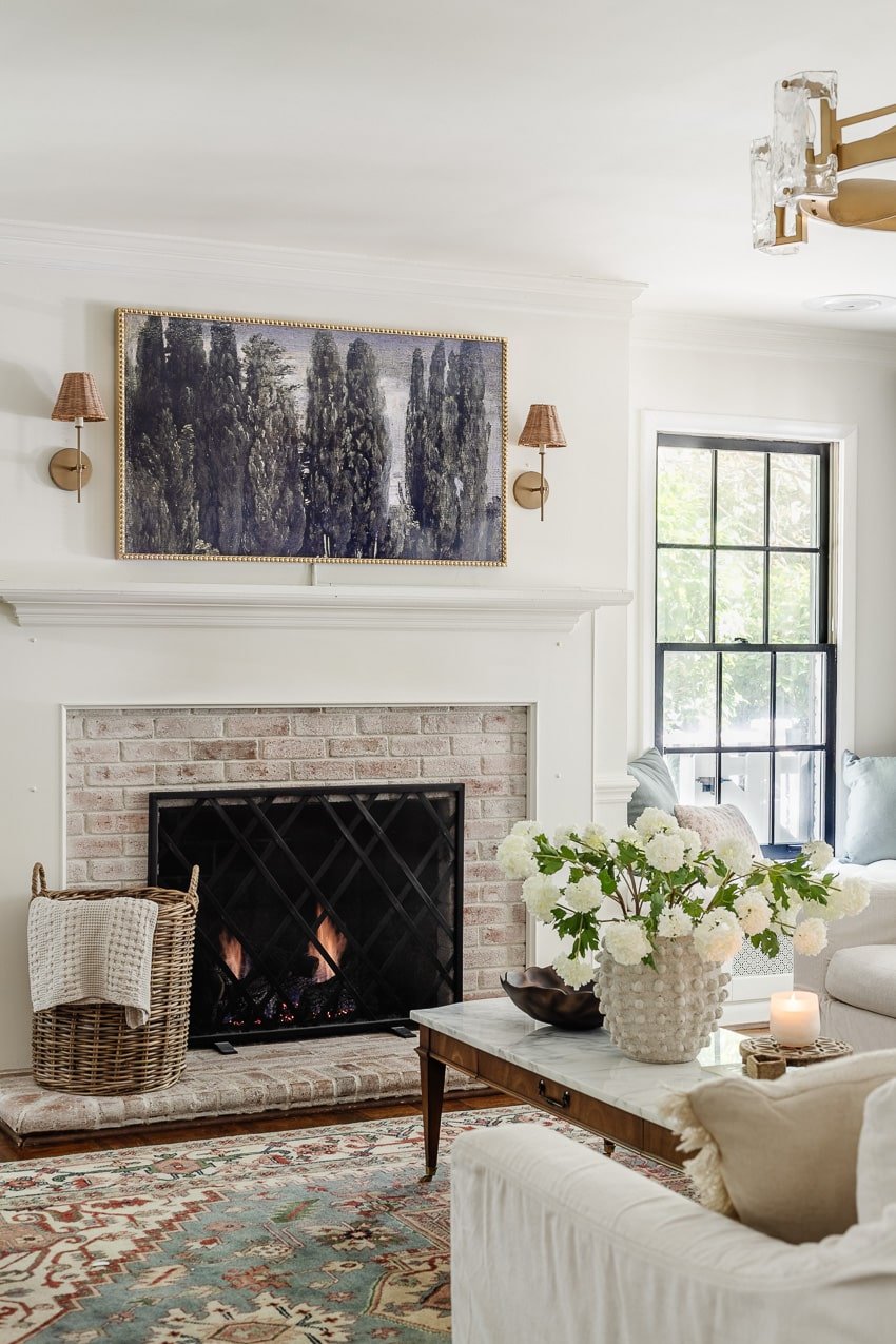DIY bobbin frame on a Samsung frame TV + rattan sconces above a limewashed brick fireplace