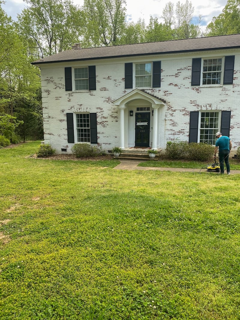 limewashed brick house before lawn makeover