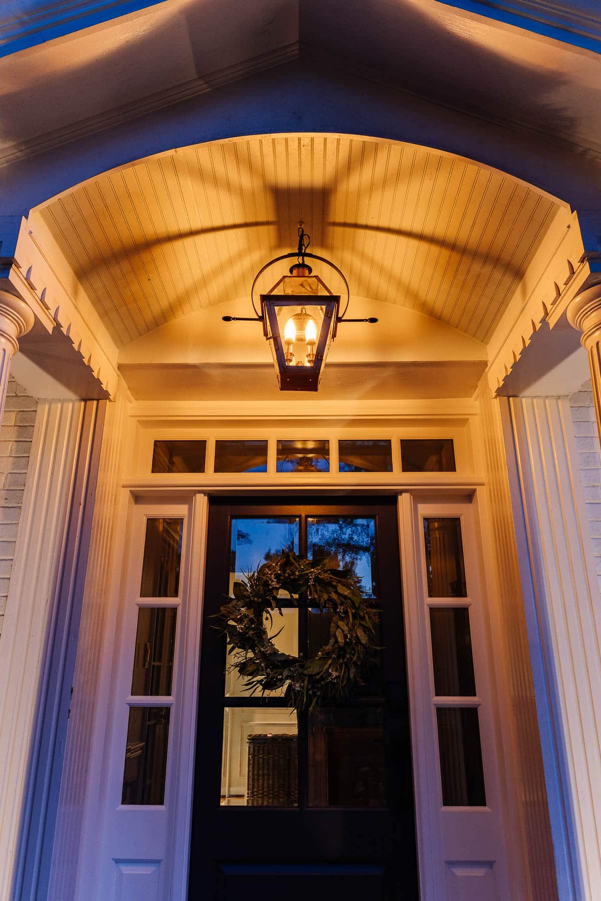 fake gas lantern on a front porch with flickering flame light bulbs at night