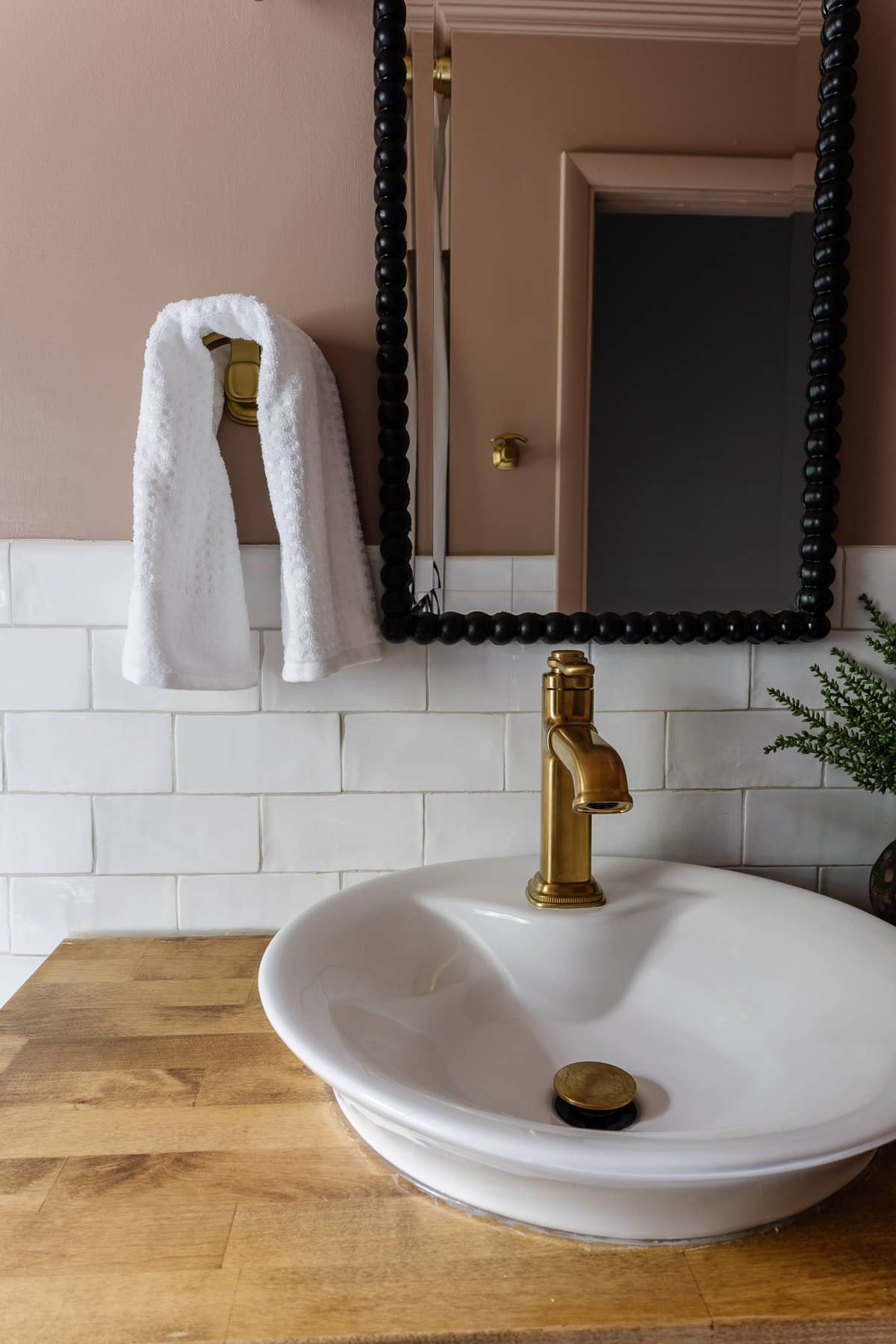 Behr Postmodern Mauve pink bathroom with subway tile and black beaded mirror