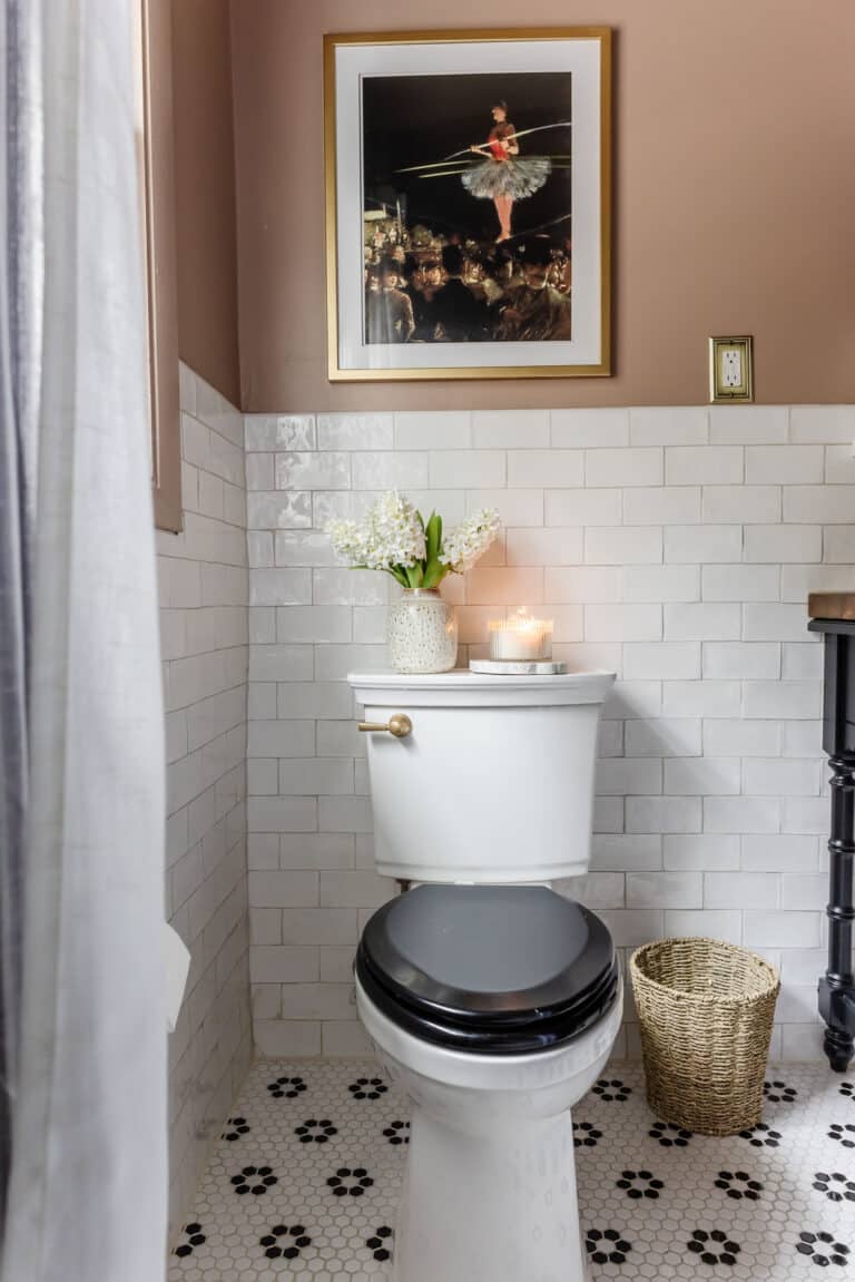 toilet with black toilet lid and subway tile with pink bathroom walls
