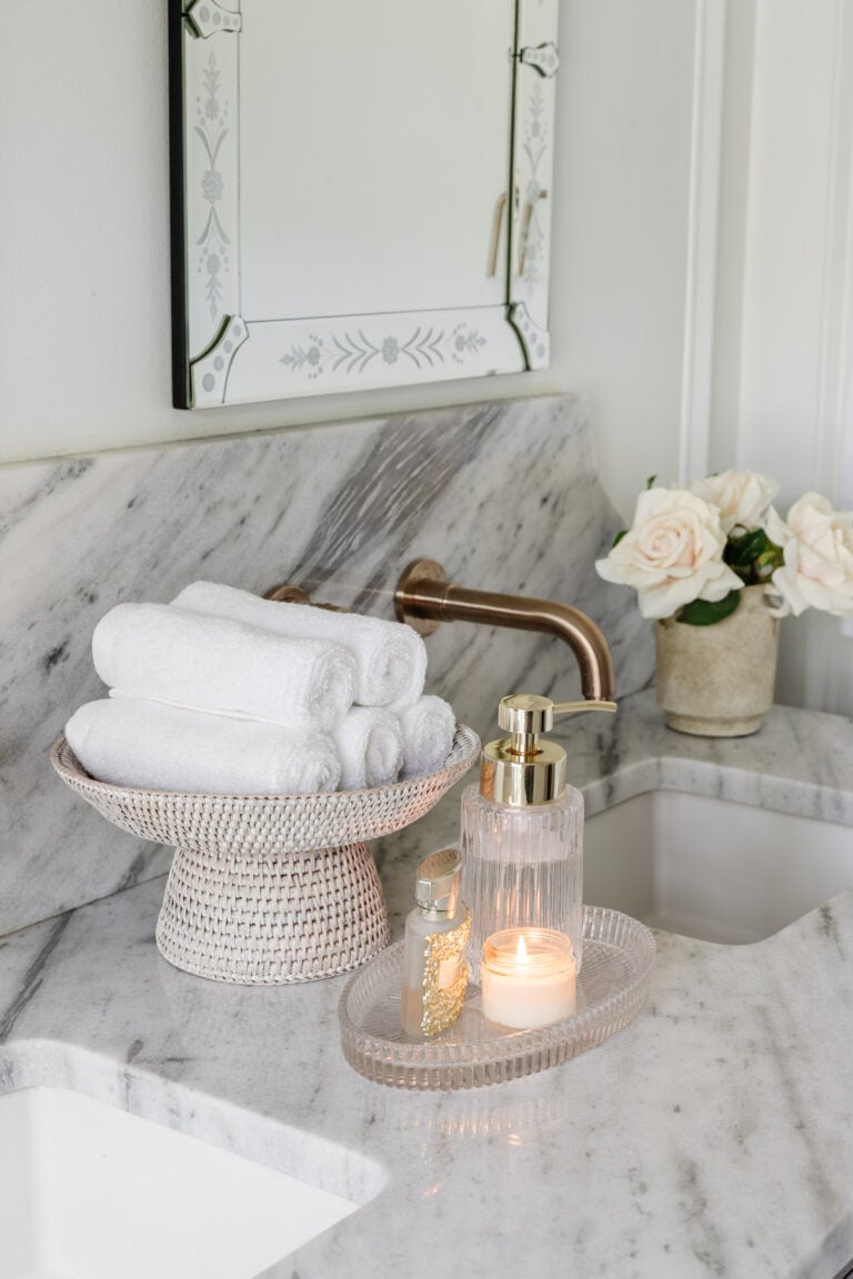 rattan pedestal bowl used as towel holder on bathroom countertop