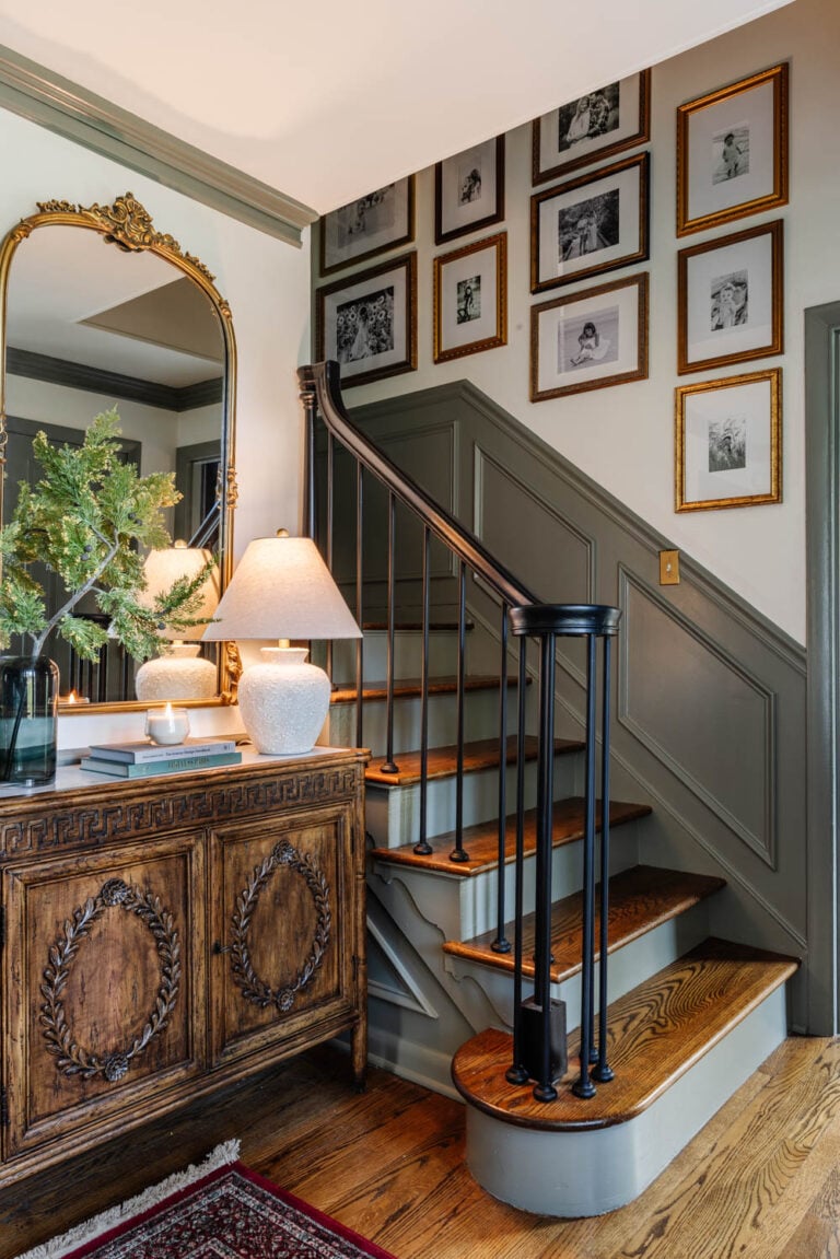 stairway gallery wall with antique style frames in a traditional foyer