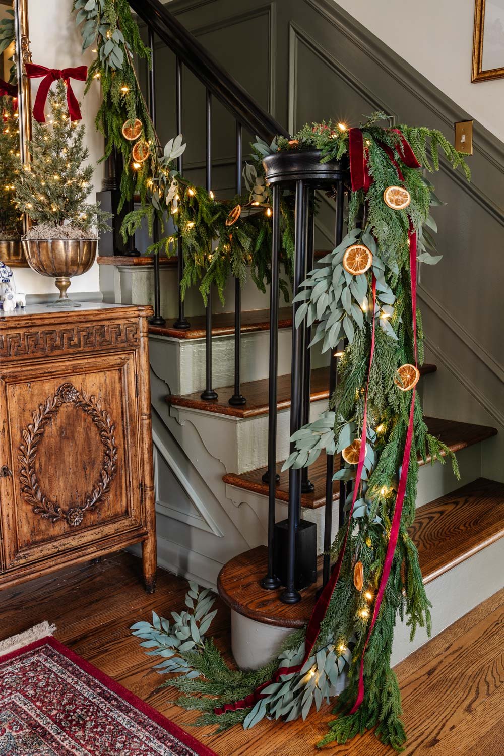 staircase railing garland with dried orange slices and red ribbon