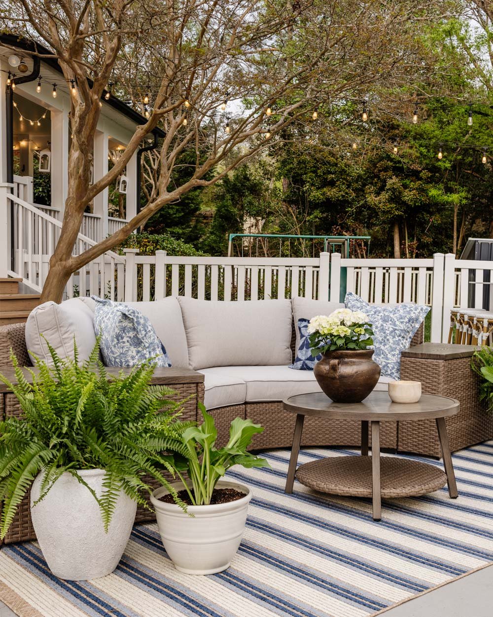 curved outdoor furniture set with blue striped patio rug