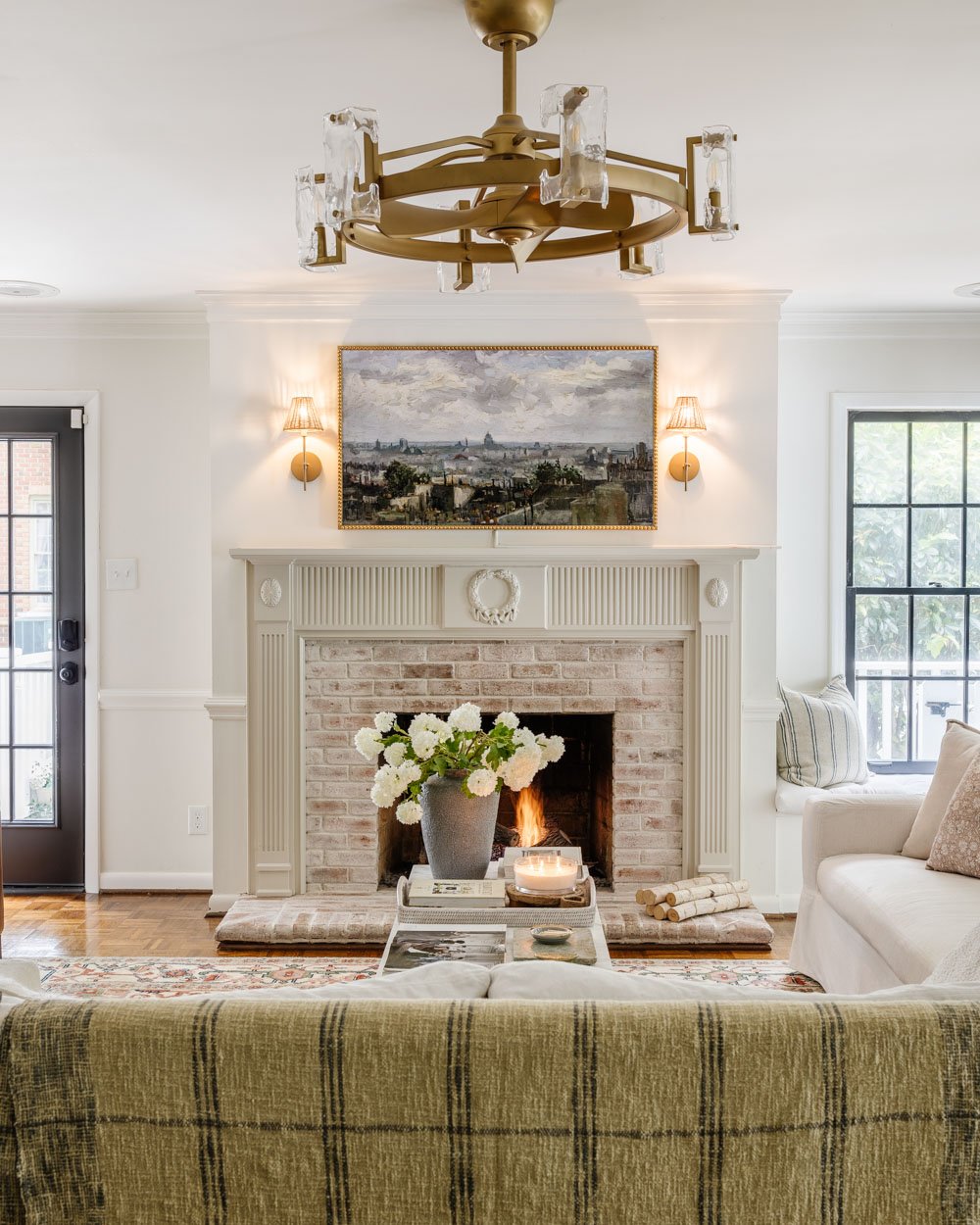 white living room with black doors and limewashed brick fireplace
