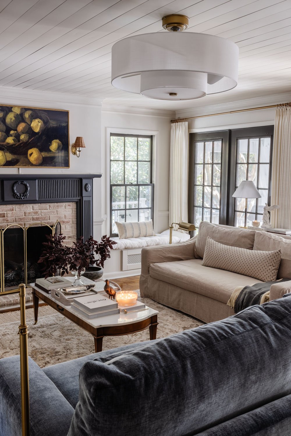 sala de estar con repisa de chimenea azul, mesa de café de mármol y candelabro moderno