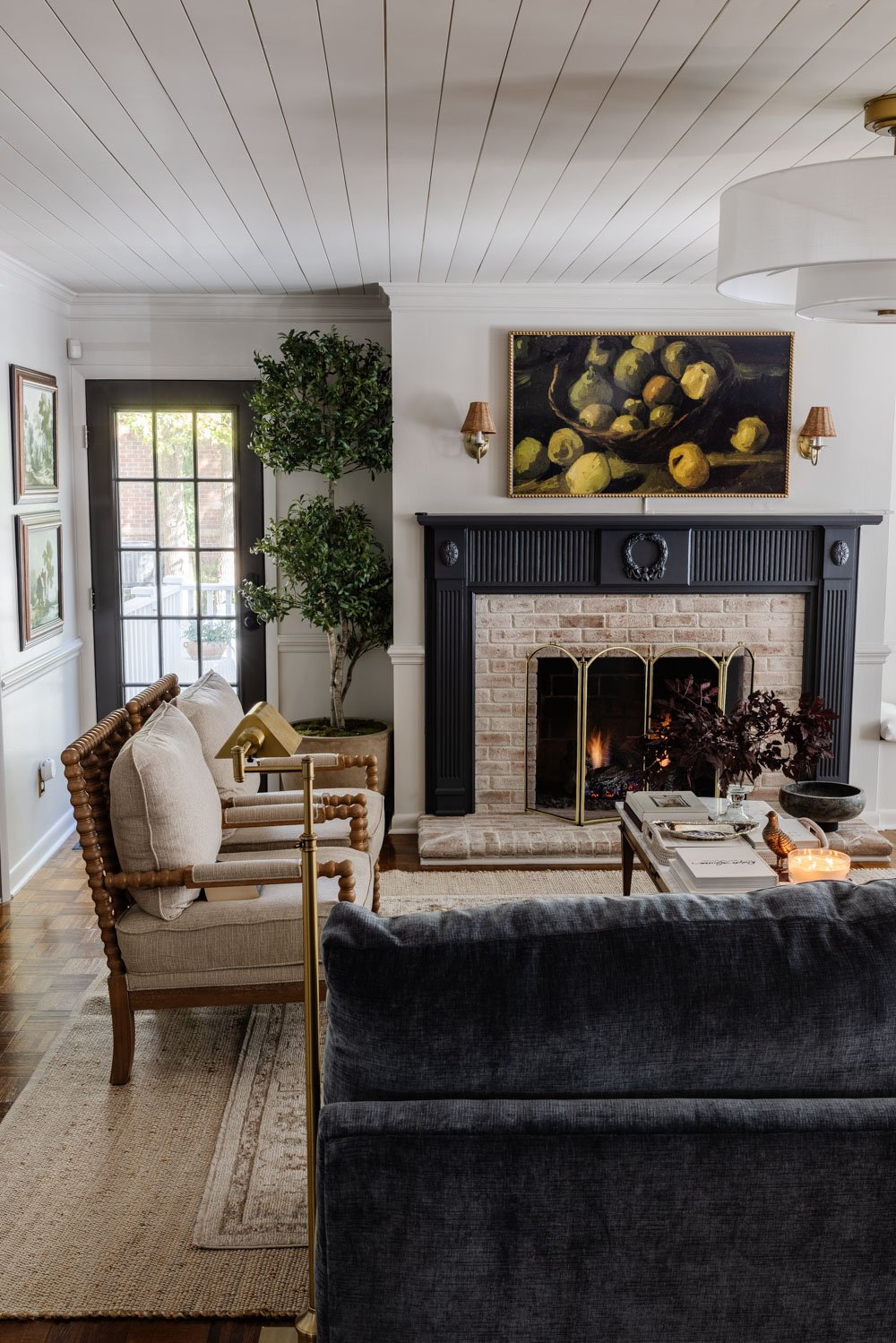 sala de estar con repisa de chimenea azul, mesa de café de mármol y candelabro moderno