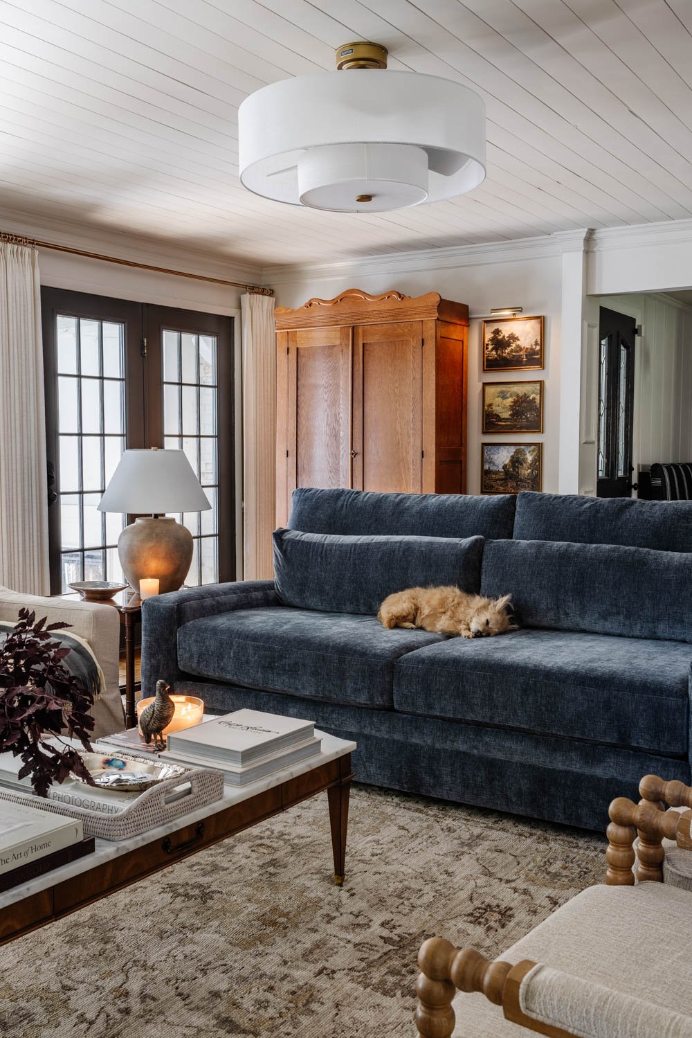 Sofá azul en el salón con armario y vestíbulo.