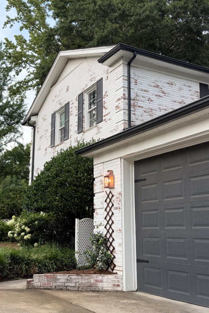 garage curb appeal with copper lanterns, star jasmine, and outdoor trash can hiding panels