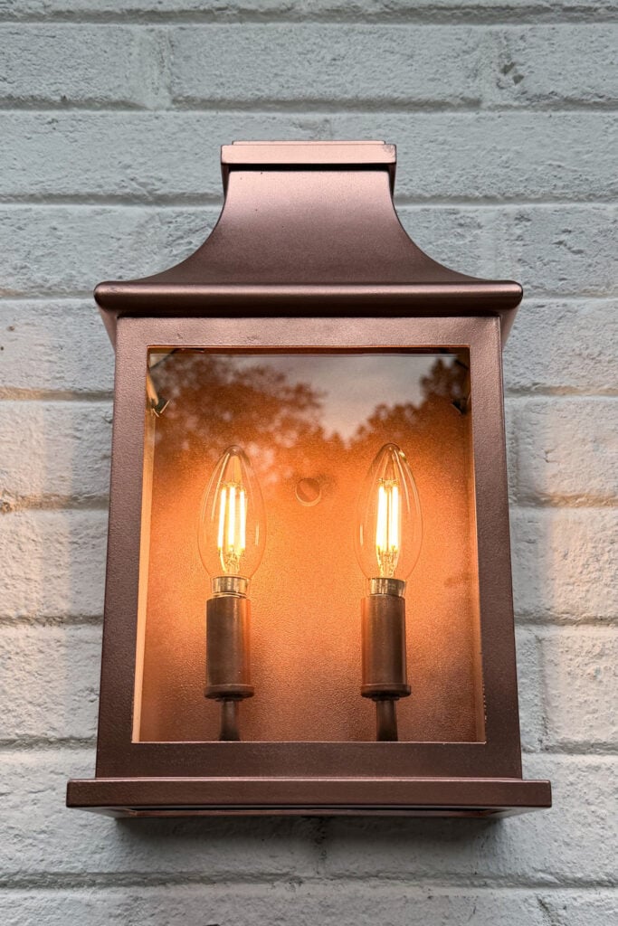 garage curb appeal with copper lanterns, star jasmine, and outdoor trash can hiding panels