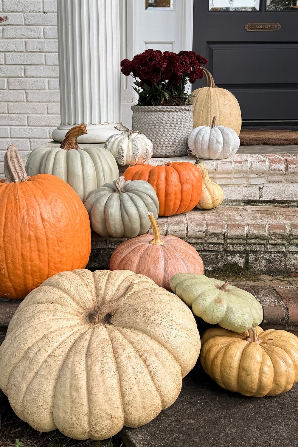 realistic fake pumpkins on limewashed brick porch steps