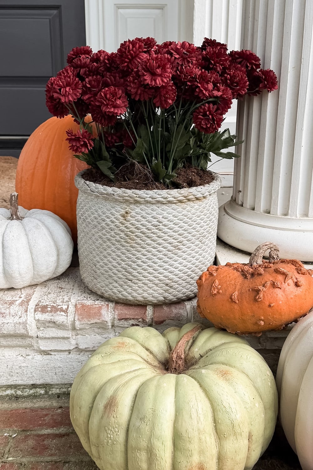 realistic fake pumpkins on limewashed brick porch steps