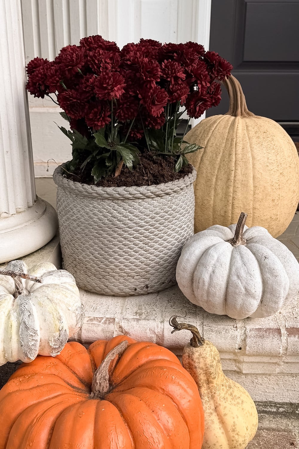 realistic fake pumpkins on limewashed brick porch steps
