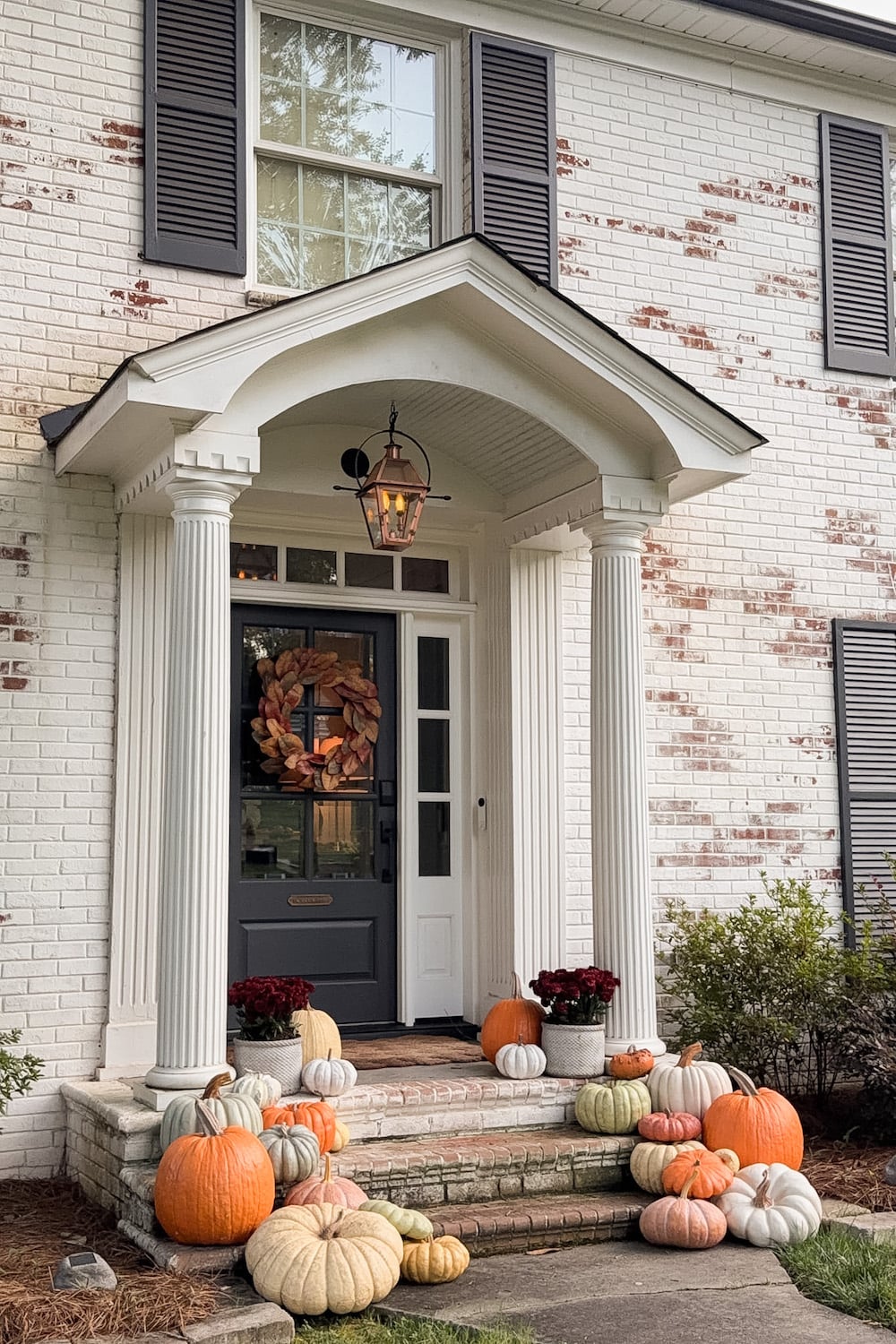 realistic fake pumpkins on limewashed brick porch steps