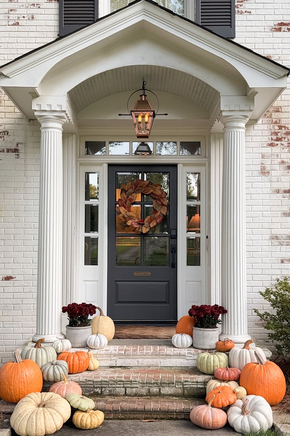 realistic fake pumpkins on limewashed brick porch steps