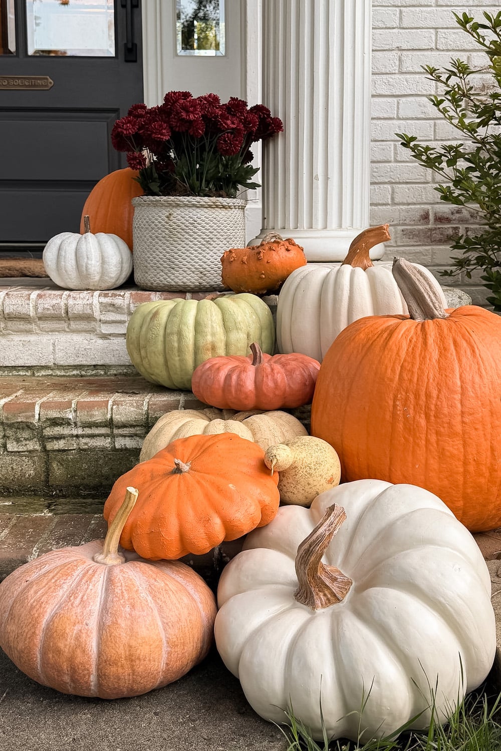 realistic fake pumpkins on limewashed brick porch steps